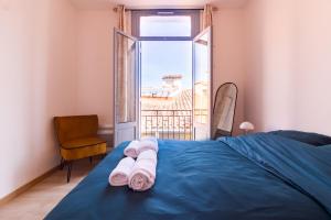una camera da letto con un letto blu e una finestra di Appartement moderne et élégant Michel Torrent a Perpignano