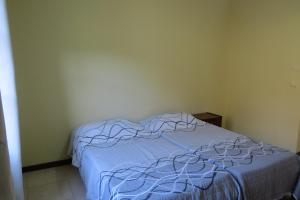 - une chambre avec un lit et une couverture bleue dans l'établissement Garden House, à Lopes