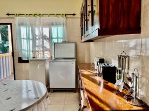 Il comprend une cuisine équipée d'un réfrigérateur blanc et d'un comptoir. dans l'établissement Garden House, à Lopes