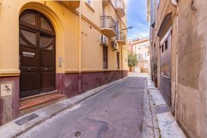 una strada vuota in un vicolo tra gli edifici di Appartement moderne et élégant Michel Torrent a Perpignano