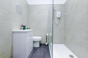 a bathroom with a shower and a toilet and a sink at Old Bank Studio Apartments in Bolton