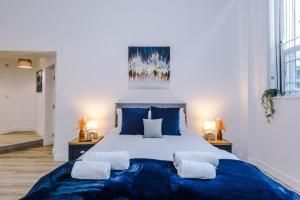a bedroom with a large bed with blue sheets and pillows at Old Bank Studio Apartments in Bolton