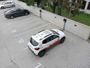 un coche blanco está estacionado en un estacionamiento en ADLER Studio - prywatny taras przy pokoju, dostęp na kod- BEZPŁATNY PARKING, en Łódź
