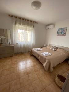 a bedroom with a large bed and a window at IL TULIPANO in Civitavecchia