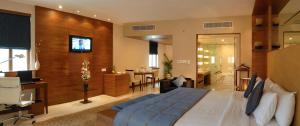 ハイデラバードにあるザ マノハー ハイデラバードのベッドルーム(大型ベッド1台付)、リビングルームが備わります。