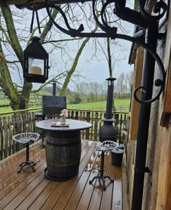 a patio with a table and chairs on a wooden deck at Tree House in Thirsk