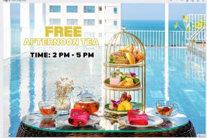 un anuncio para un té de la tarde en una mesa junto a una piscina en Golden Lotus Luxury Hotel Danang, en Da Nang