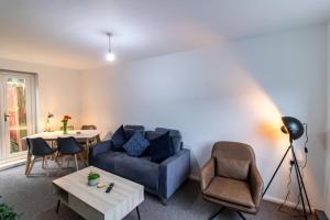 a living room with a blue couch and a table at K Suites - Lime Grove in Ryton