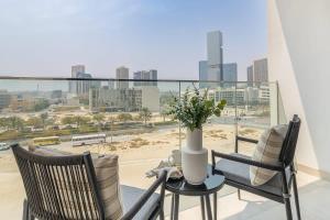 a balcony with chairs and a table with a view of the city at Frank Porter - Pantheon Elysee in Dubai