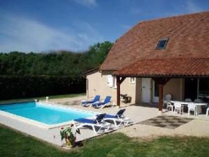 Casa con piscina con sillas y mesa en Villa de 3 chambres avec piscine privee jardin clos et wifi a Loubressac, en Loubressac