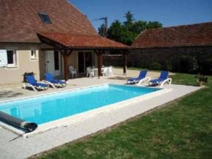 ein Pool mit blauen Stühlen und ein Haus in der Unterkunft Villa de 3 chambres avec piscine privee jardin clos et wifi a Loubressac in Loubressac