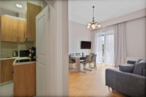 cocina y sala de estar con sofá y mesa en Olympic Zeus Apartment en Atenas
