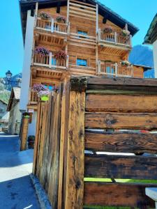 een houten huis met een houten hek ervoor bij Chalet du Paradis in Cogne