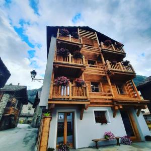 a building with wooden balconies and flowers on it at Chalet du Paradis in Cogne