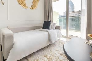 a living room with a white couch and a large window at Frank Porter - Reva Residences in Dubai +17 photos