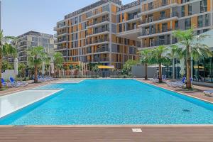 a large swimming pool in front of a building at Frank Porter - Noor 3 Midtown in Dubai