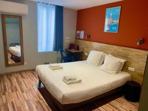 a hotel room with a bed with towels on it at Logis Hotel Yseria - Historical Center in Agde +12 photos