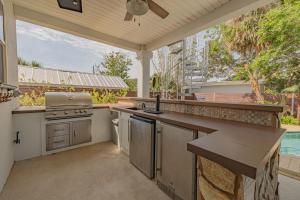 an outdoor kitchen with a stove and a pool at 4BD 3BR Pool Paradise 1 mile from Beach & Downtown in Saint Augustine