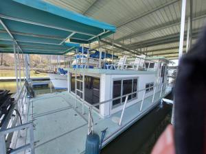 a boat docked at a dock with chairs on it at Cute & Cozy Houseboat Near Chattanooga in Haletown