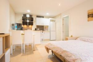 1 dormitorio con 1 cama y cocina pequeña en Casa de invitados para 6 personas, en Carmona
