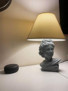 une statue d'un buste assis sur une table à côté d'une lampe dans l'établissement Guest House Dei Papi, à Viterbe