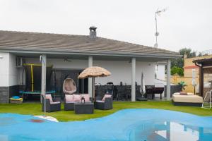 un patio con sillas, una sombrilla y una piscina en Casa de invitados para 6 personas, en Carmona