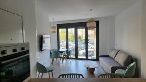 een woonkamer met een bank en een tafel met stoelen bij RentalSevilla La Salle in Sevilla