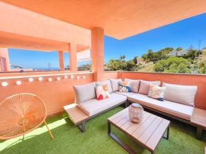 patio z 2 kanapami i stołem w obiekcie La Reserva Beach & Golf Apartment w Marbelli