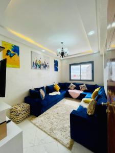 sala de estar con sofá azul y alfombra en appartement au centre d´Agadir, en Agadir