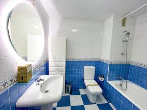 a blue and white bathroom with a sink and a toilet at La Reserva Beach & Golf Apartment in Marbella