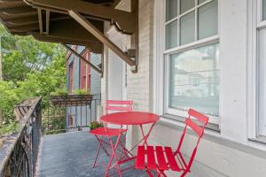 a red table and two chairs on a porch at Stunning 2BD luxury apt perfect NOLA location in New Orleans