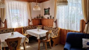 a dining room with two tables and a couch at Haus Blach in Kurort Oberwiesenthal