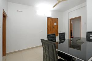 a conference room with a glass table and chairs at Hillside Hideaway Gudalur in Gūdalūr