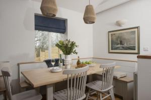 a kitchen and dining room with a wooden table and chairs at Lobbs Cottage, St Mawgan in Saint Mawgan