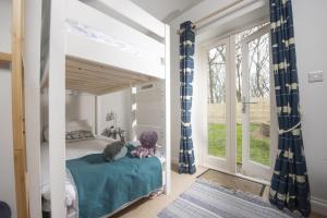 a bedroom with a bed with blue and white curtains at Lobbs Cottage, St Mawgan in Saint Mawgan