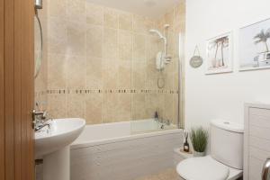 a bathroom with a tub and a toilet and a sink at Lobbs Cottage, St Mawgan in Saint Mawgan