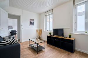 uma sala de estar com um sofá e uma televisão em Maison L'Escale Paisible em Anstaing