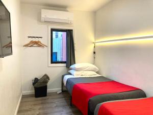 a room with two beds and a window at Modern GuestHouse Ironbound Newark with KITCHEN-FastTrainToNYC-OneStopToAirport in Newark