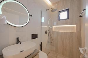 bagno con lavandino bianco e specchio di Villa Xhefri a Sarandë