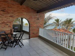 a patio with a table and chairs on a balcony at Breeze & Shade Beira Mar in Parnamirim