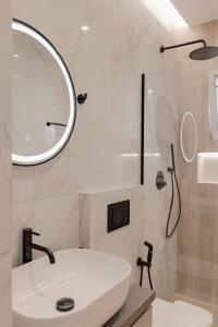 a white bathroom with a sink and a mirror at Villa Xhefri in Sarandë