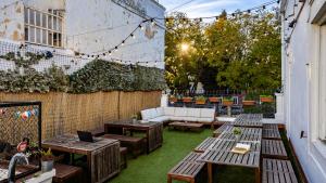 a patio with tables and a couch in a yard at Hostel Casa d'Alagoa in Faro