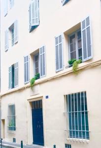 un edificio blanco con puertas y ventanas azules en Èrsextius MMC Aix-en-Provence, en Aix-en-Provence