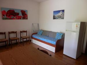 a room with a bed with chairs and a refrigerator at Il Gamberetto in Principina a Mare