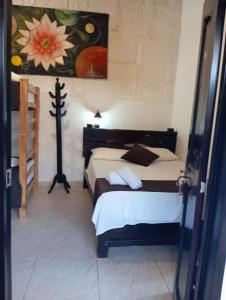 una camera da letto con un letto e un dipinto sul muro di SANTANDER ALEMAN HOSTEL a San Gil