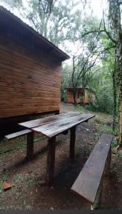 a wooden picnic table in front of a building at cabañas y camping jv in Leandro N. Alem