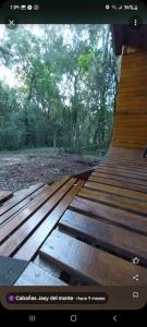 a view of a wooden bench in the woods at cabañas y camping jv in Leandro N. Alem
