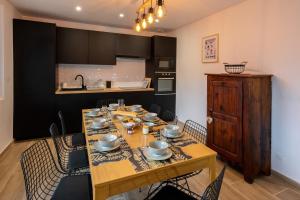 uma sala de jantar com uma mesa de madeira e cadeiras em Les Appartements de Clélia em Ax-les-Thermes