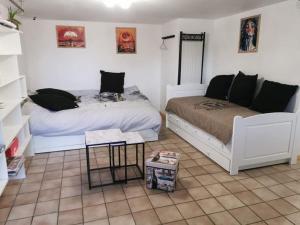 Un dormitorio con dos camas y una mesa dentro. en studio rez-de-chaussée jusqu'à 4 personnes, en Joué-lès-Tours