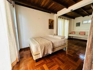 um quarto com uma cama e piso em madeira em Casa Pierre em Monterrico